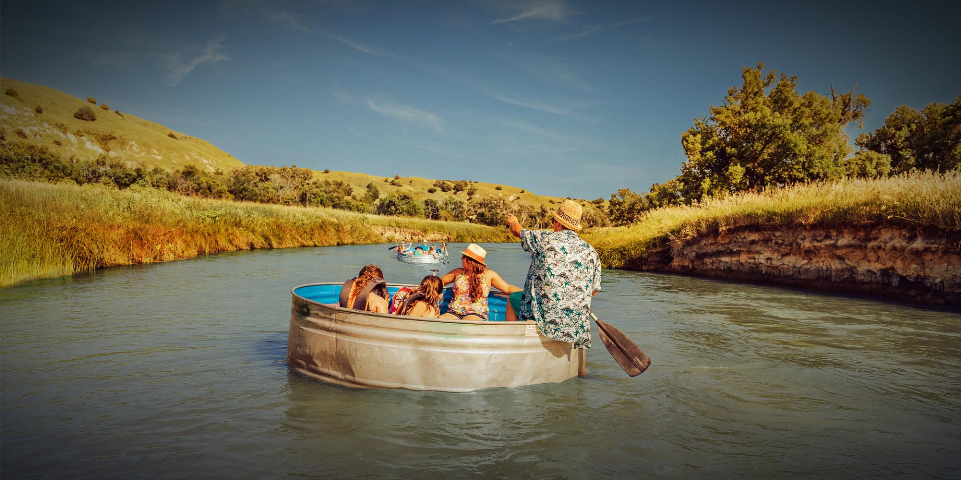 people riding in cattle tank in river