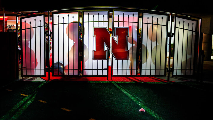 Gates in Memorial Stadium by field with band members behind them