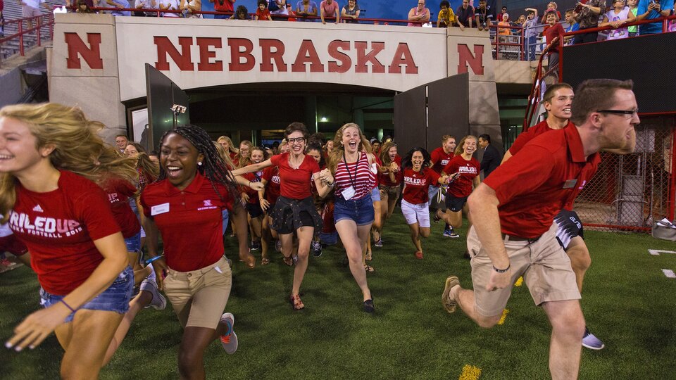Freshman students recreating the football team's Tunnel Walk by running onto the field of Memorial Stadium 