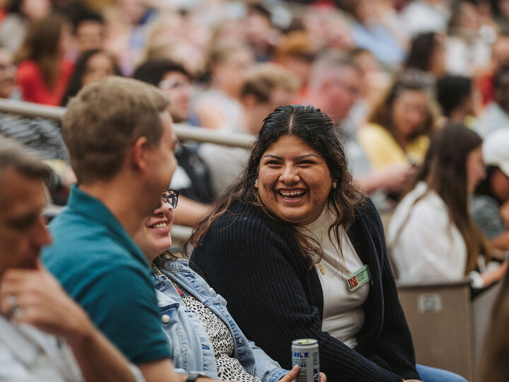University staff member sitting in auditorium and talking