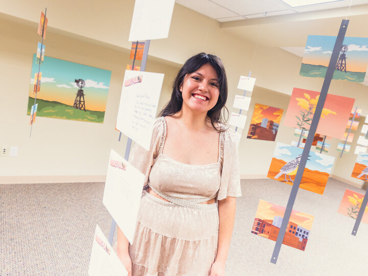 Student standing in Great Plains Art Museum gallery with letters hanging down from ceiling