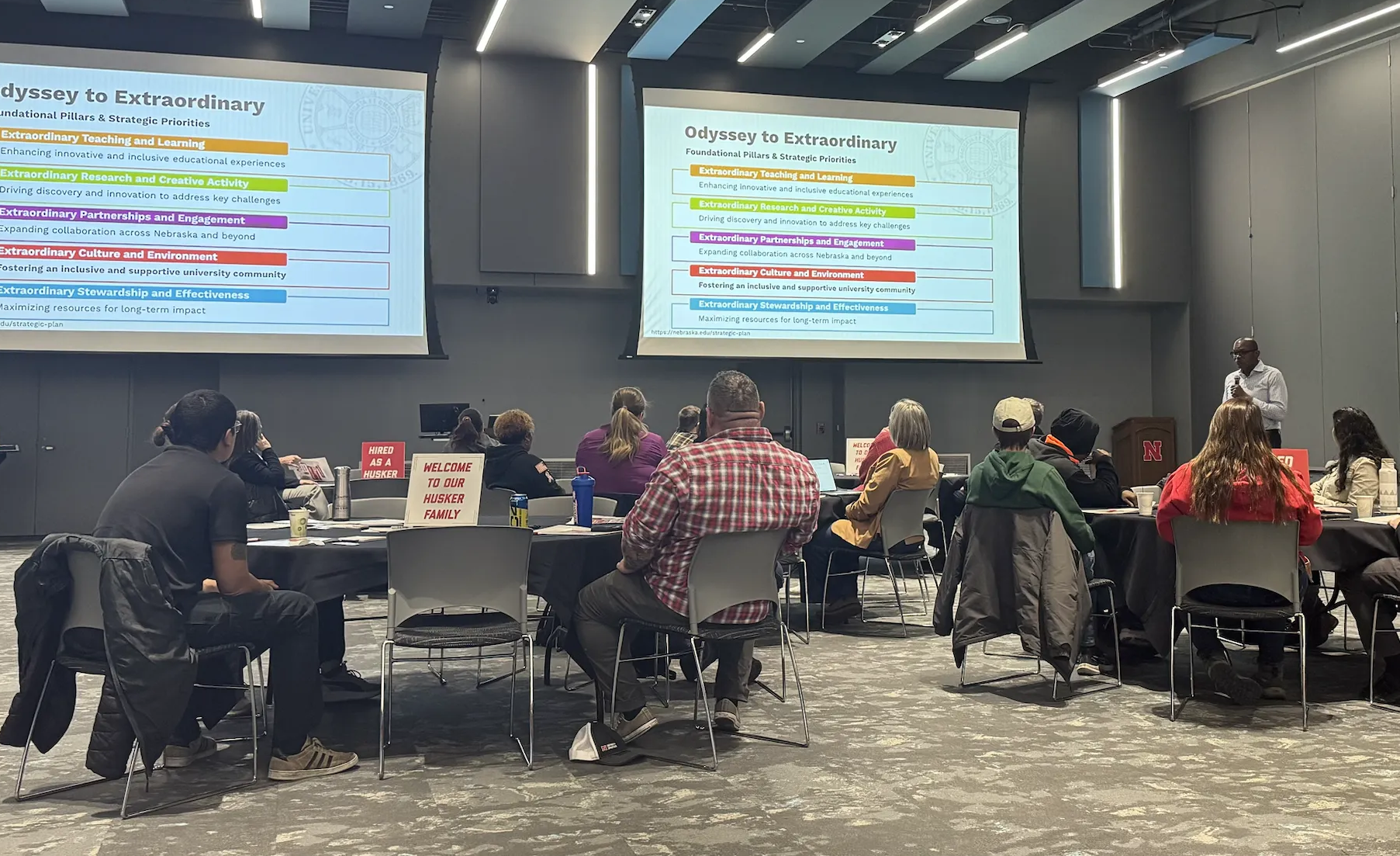 people sitting at tables watching a presentation