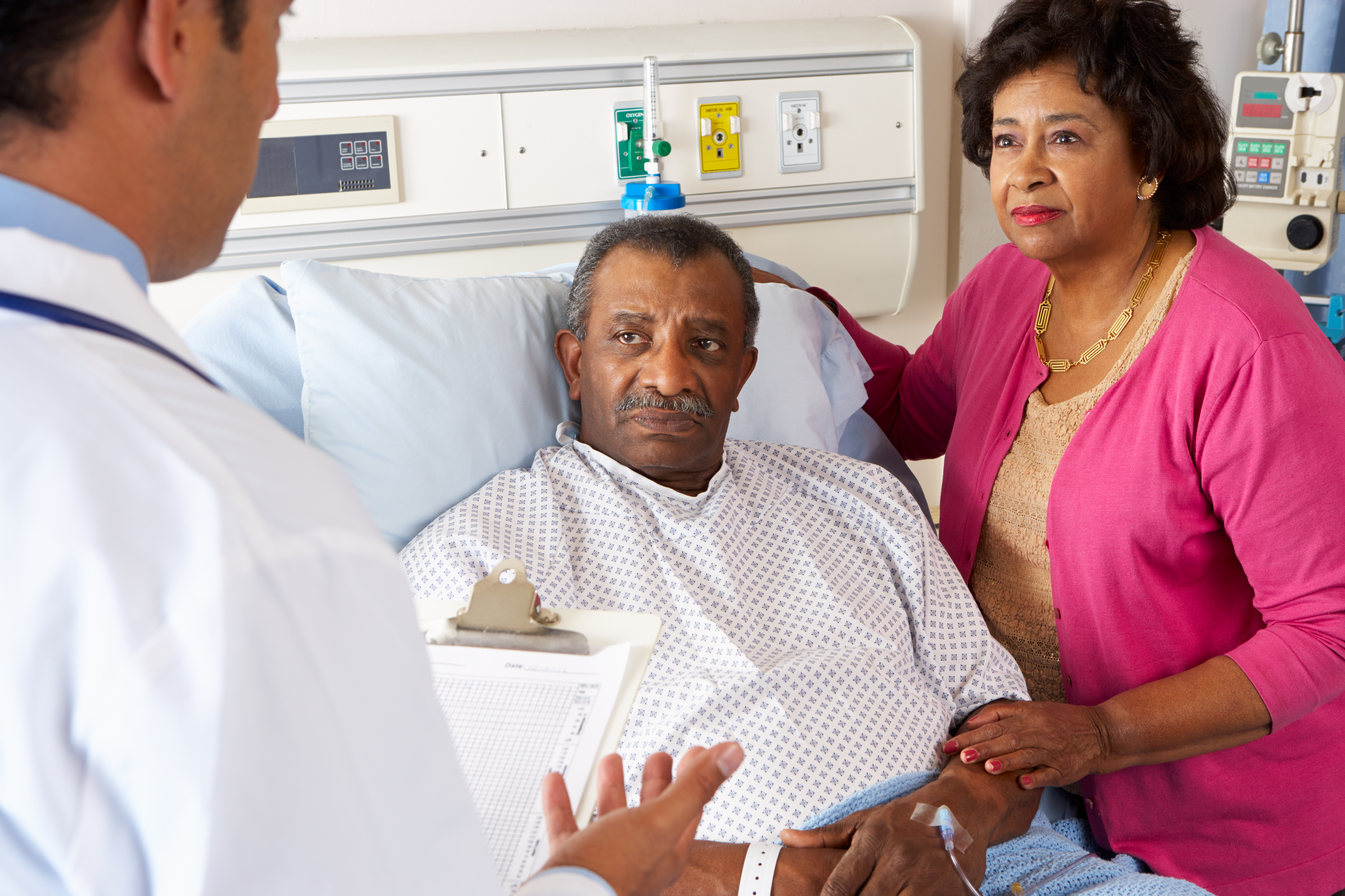 person in hospital bed with spouse listening to doctor talk