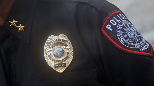 police badge and patch on uniformed shoulder