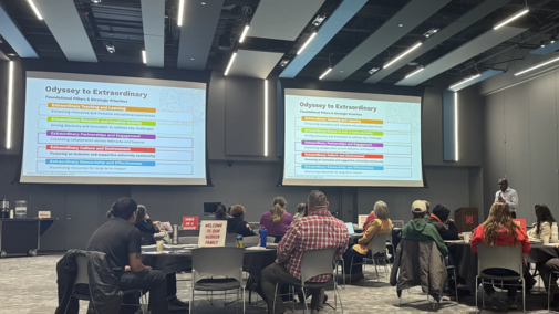 people sitting around tables listening to a presentation
