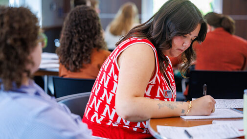 Staff member writing on paper while in a training