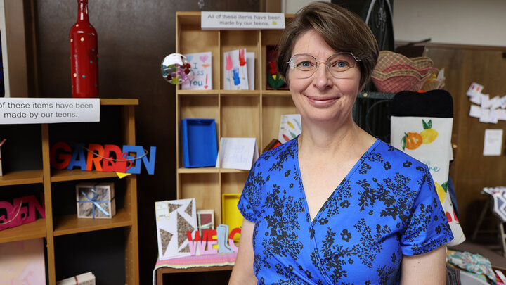 Adeline Johnson stands in front of crafts made by students at Our Place After School Care and sold at the Freedom Factory.