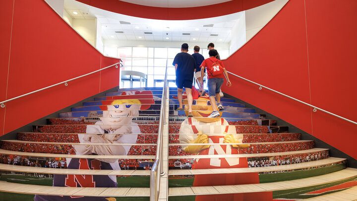 Students walk up the stairs in Nebraska Union Aug 16. The stairs were updated with new decals depicting Herbie Husker and Lil Red.