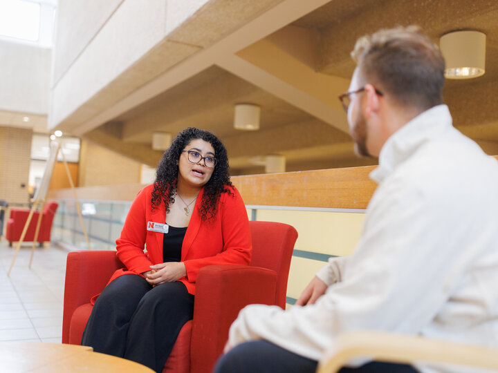 Woman in chair talking with man